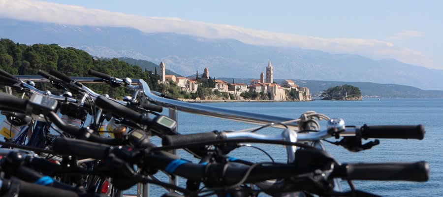 bicycles on board of a motor yacht with old town of Rab in the background